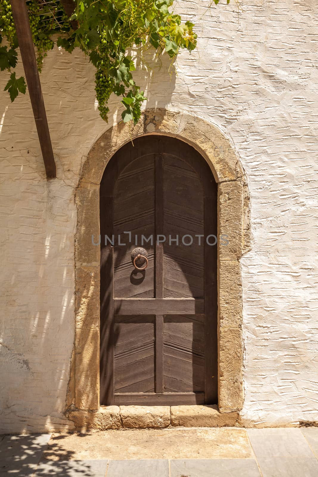 Antique wooden door with metal decor in monastery Touplu, Crete, Greece 