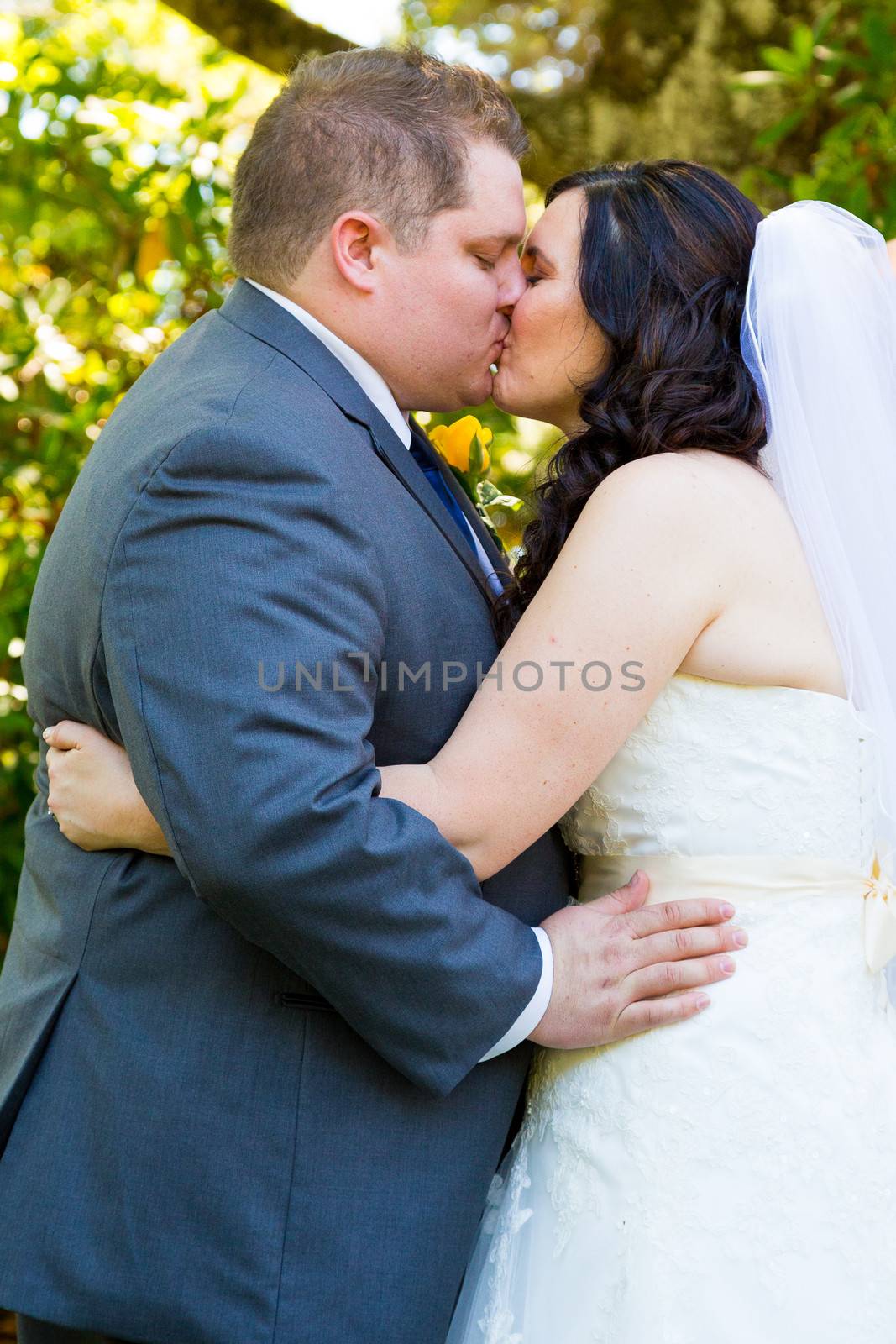 A bride and groom share their first kiss as a married couple and have a moment together during their marriage vows ceremony at an outdoor park in Oregon.