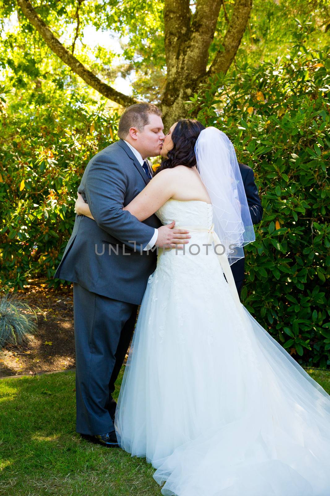A bride and groom share their first kiss as a married couple and have a moment together during their marriage vows ceremony at an outdoor park in Oregon.