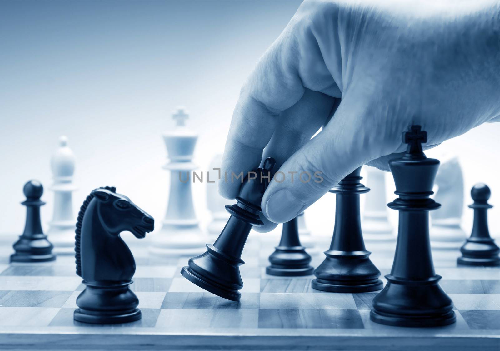 Hand moving a chess piece on board by f/2sumicron