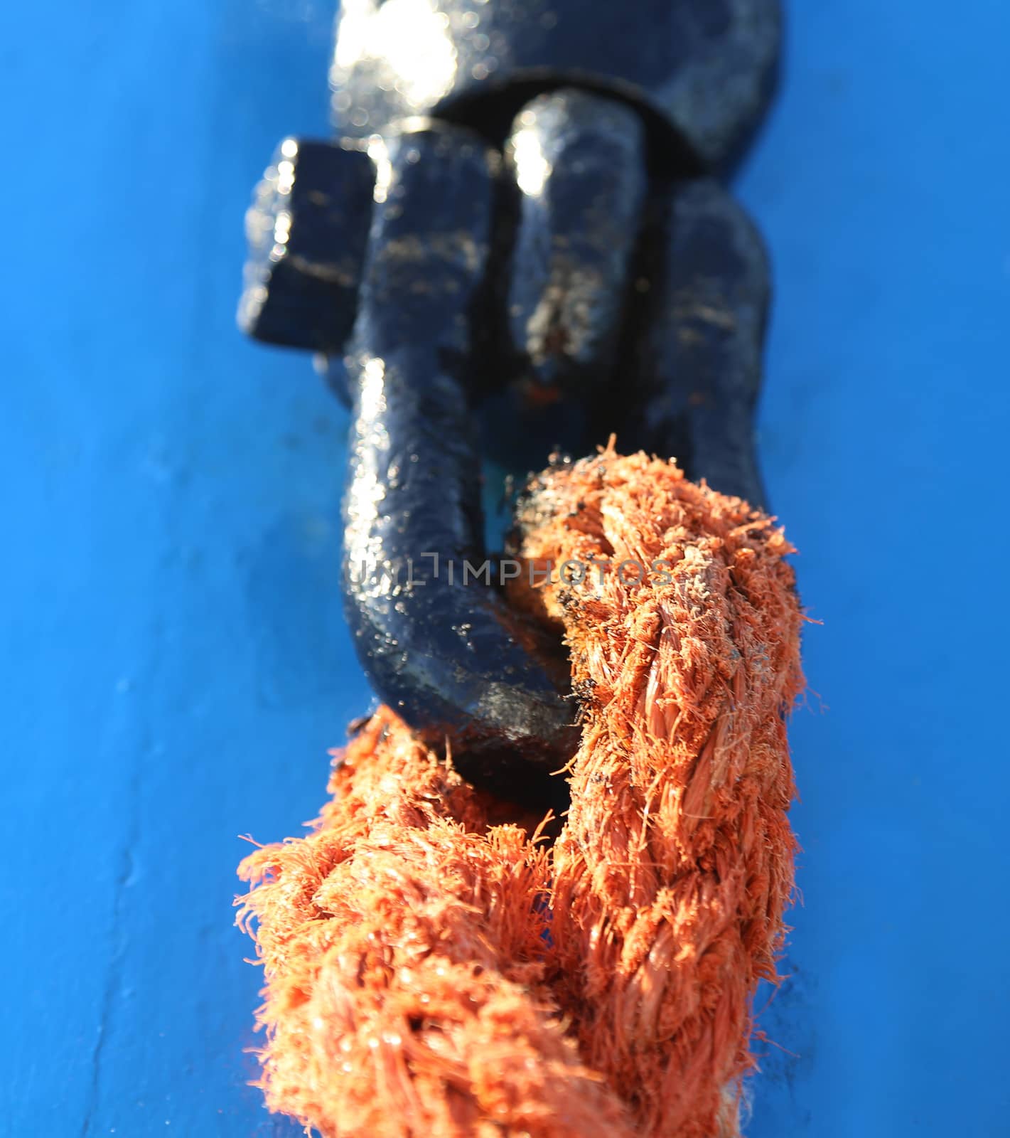 Metal Shackles Joining Ropes. Blue background. Close-up.