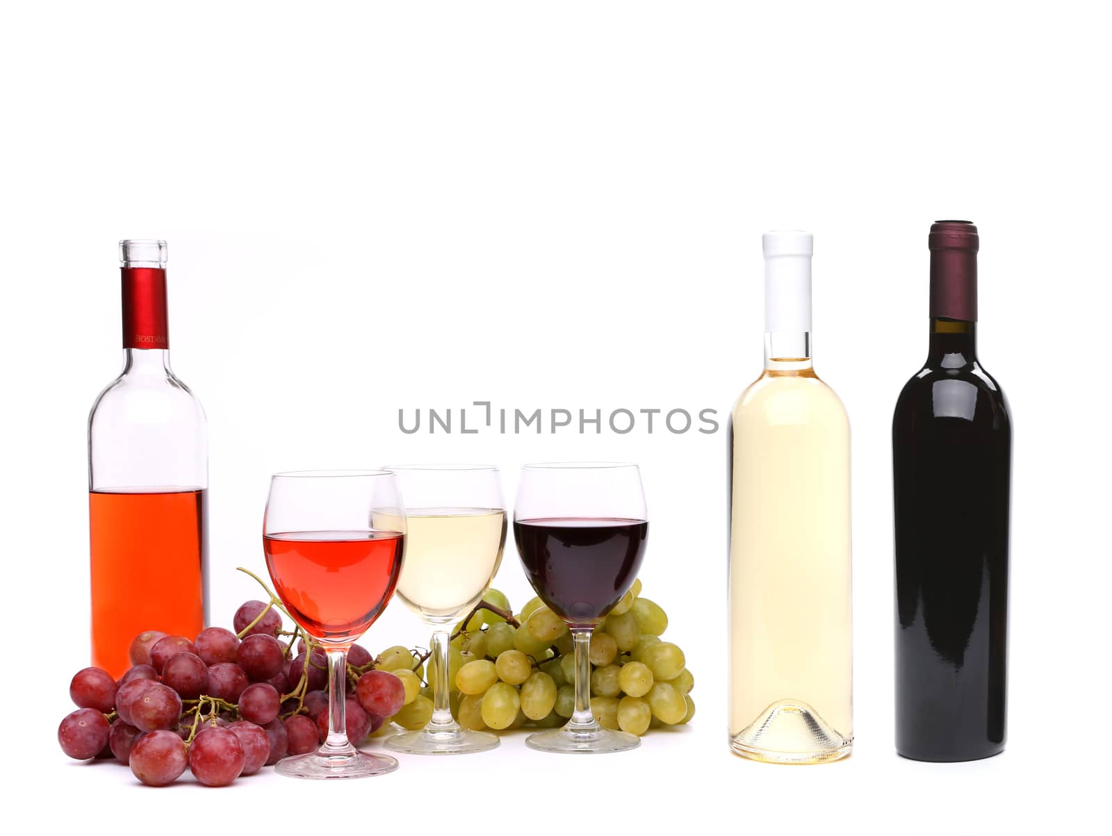 Ripe grapes, glasses and bottles of wine isolated on white