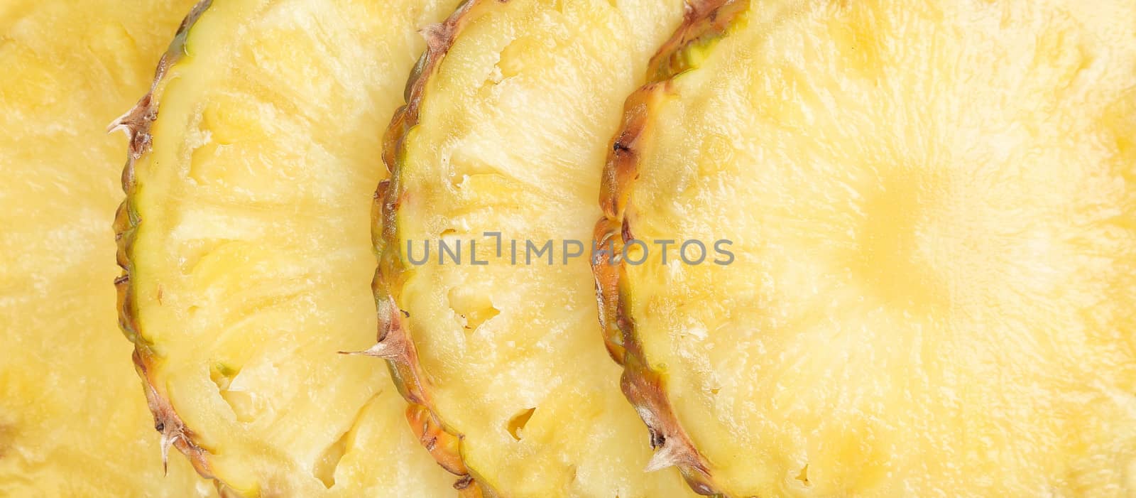 Row sliced pineapple. Close up. Whole background.