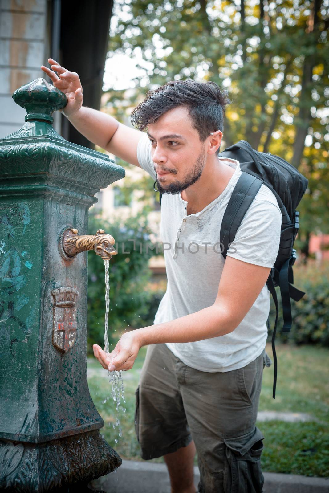stylish man refreshing at the fountain by peus