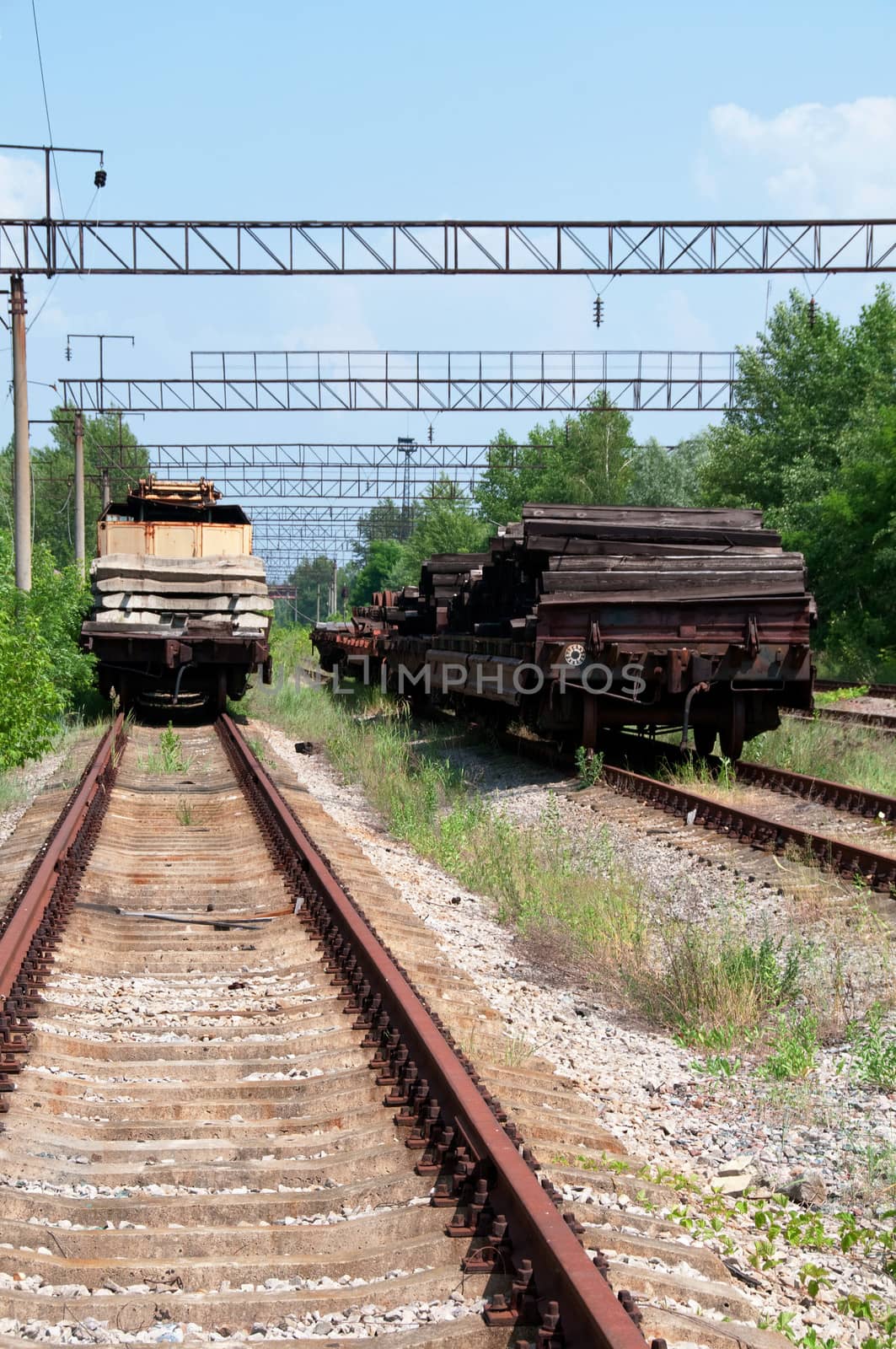 Railway tracks with cargo wagons for repairing works in green country