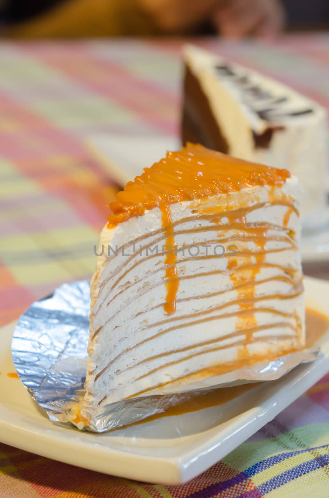 close up orange crepe cake on white plate