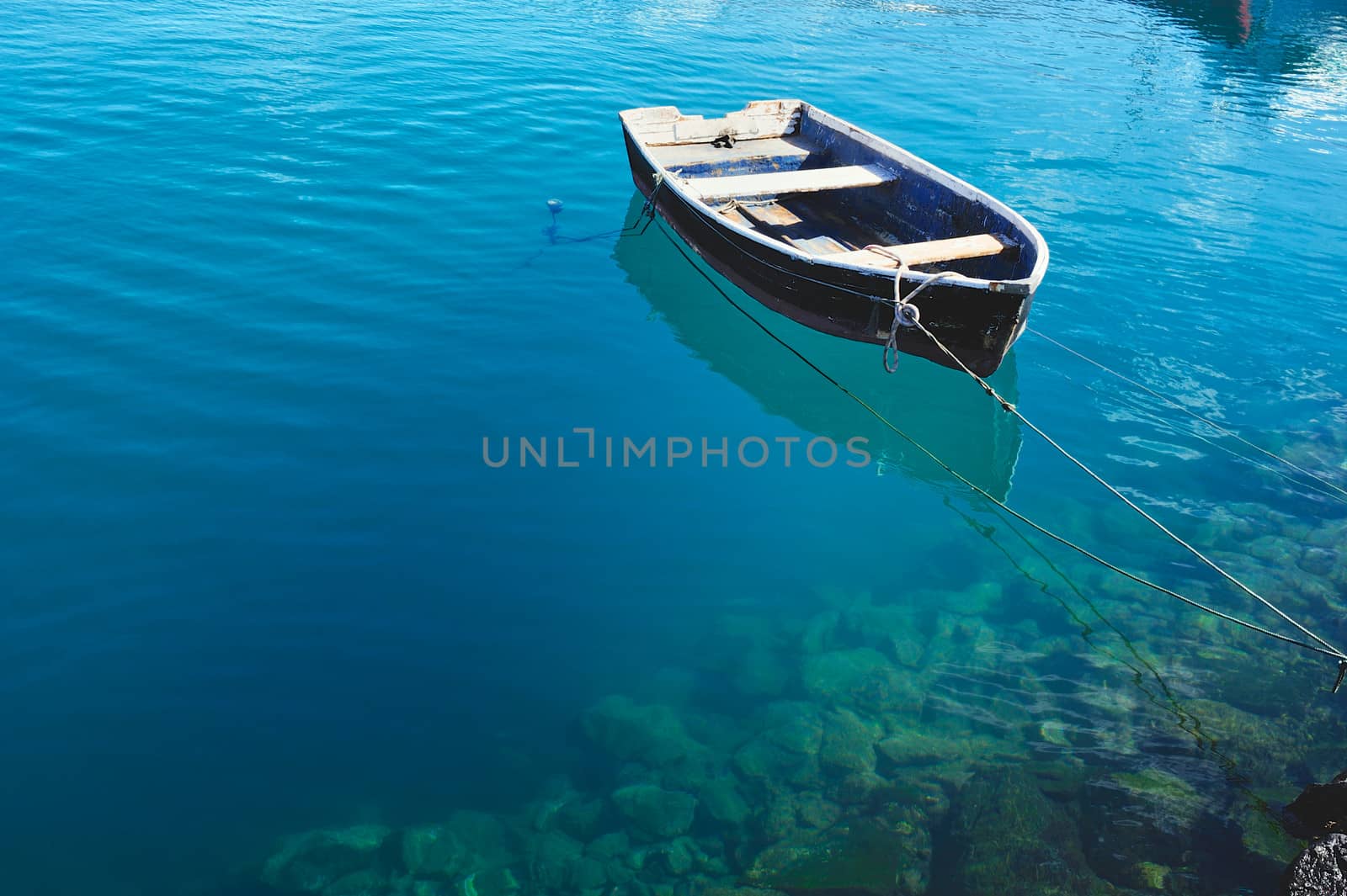 Old fishing boat on the transparent water surface