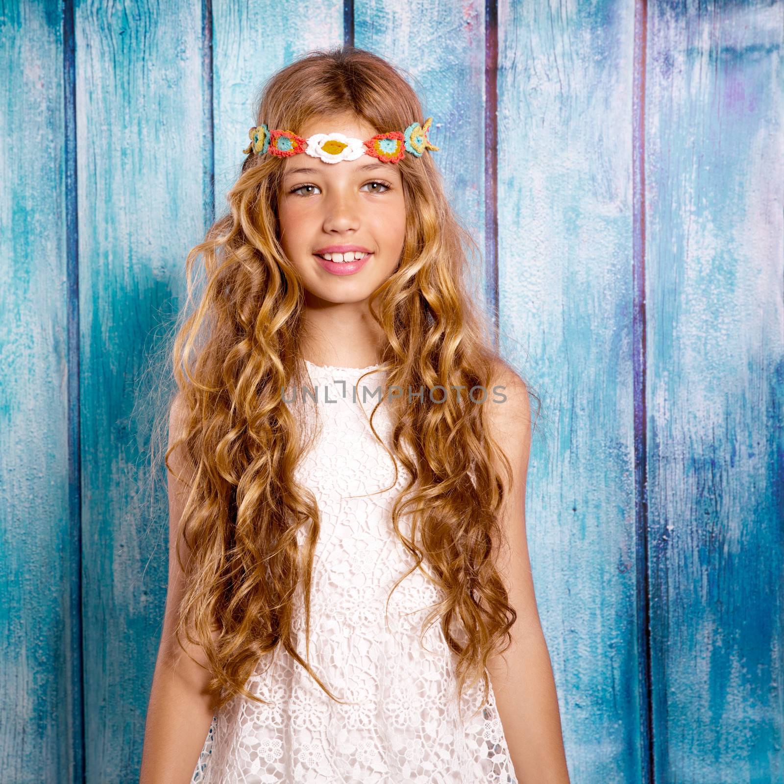 Blond happy hippie children girl smiling on blue grunge wood background