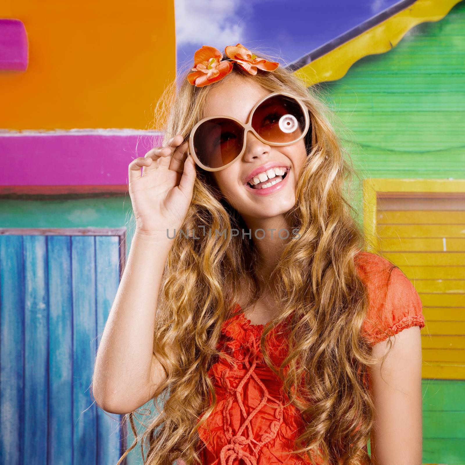 blond children happy tourist girl smiling with sunglasses on a tropical house