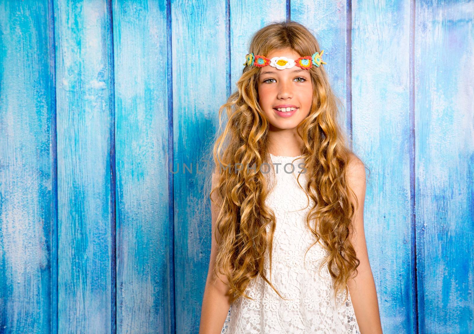 Blond happy hippie children girl smiling on blue grunge wood background