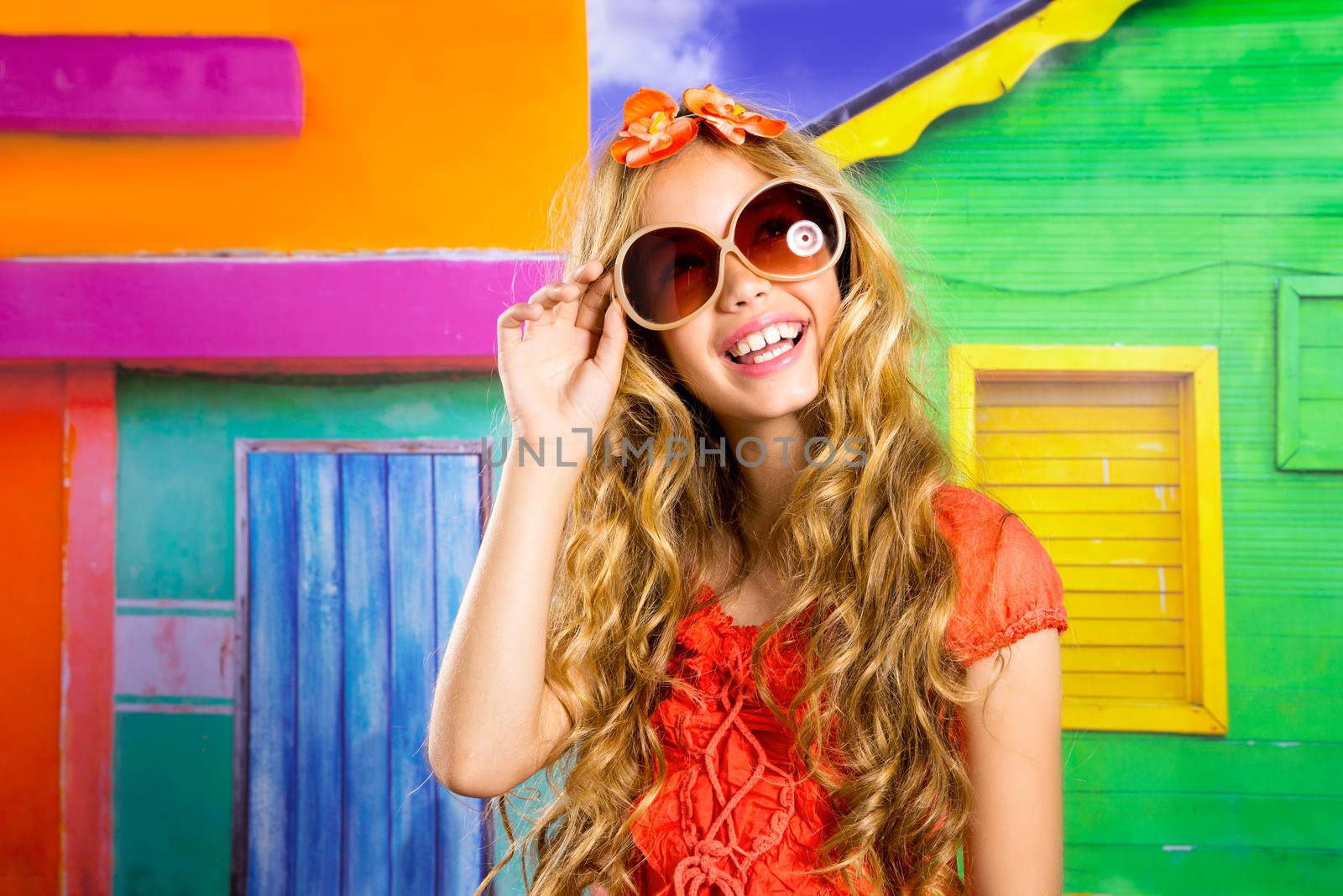 blond children happy tourist girl smiling with sunglasses on a tropical house