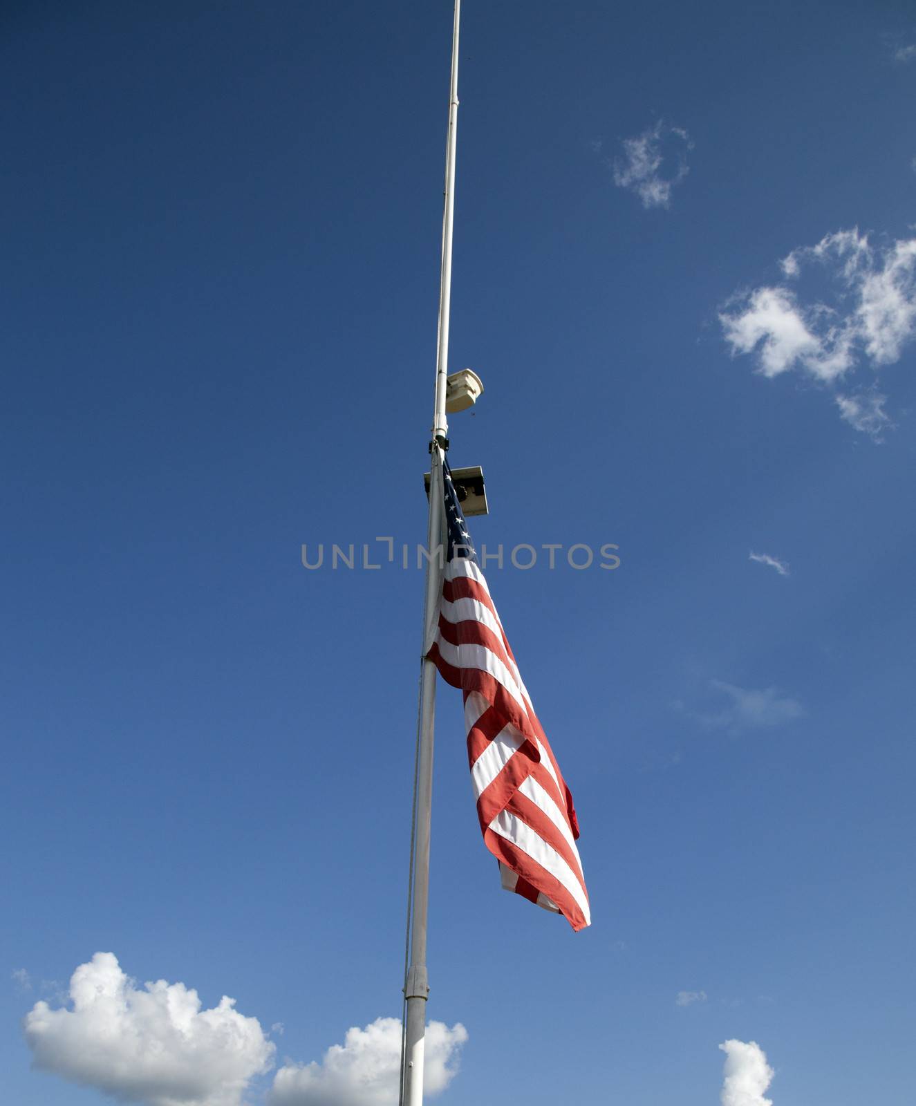 American flag at half mast with in the sky background