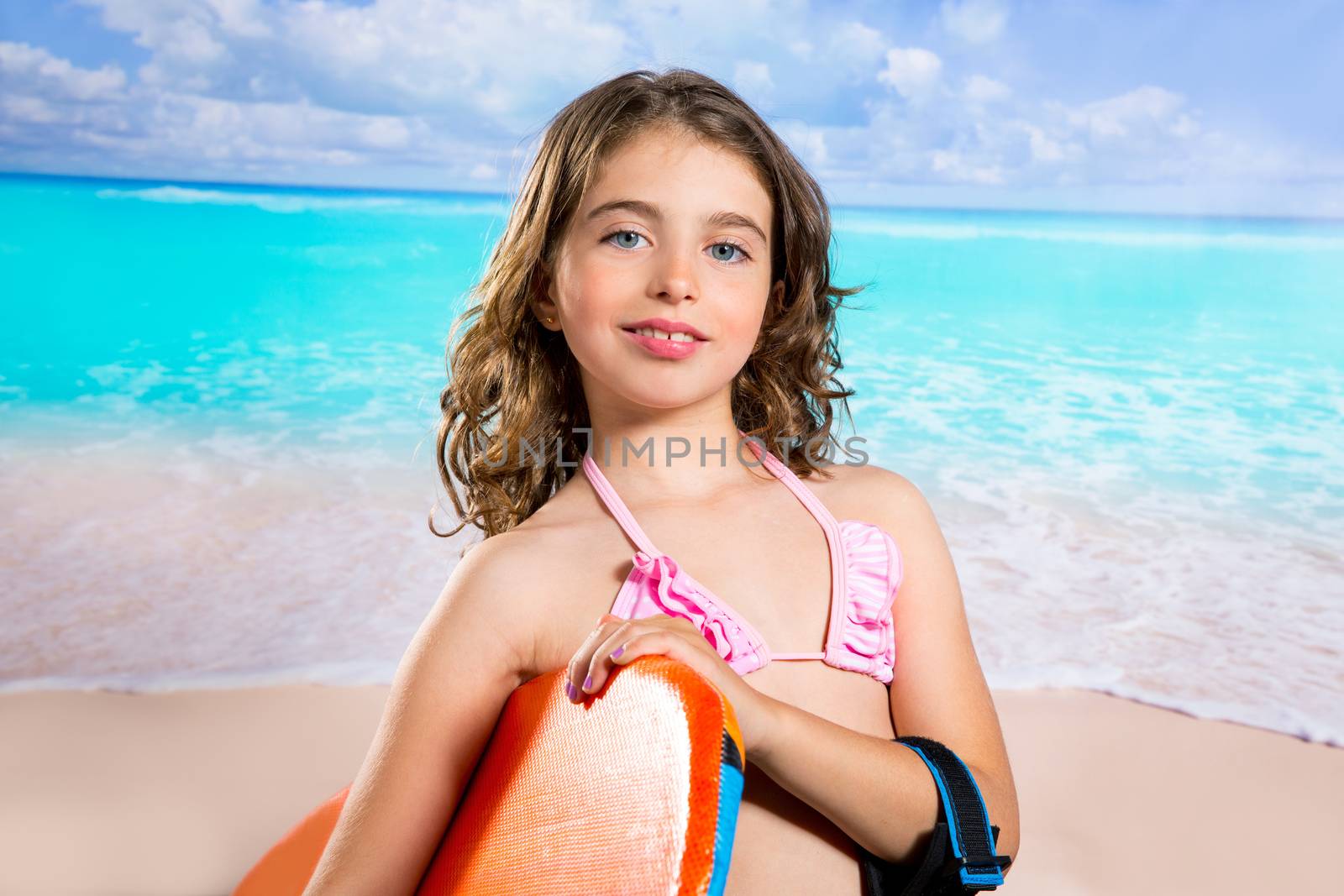 Children fashion surfer girl in tropical turquoise beach vacation smiling