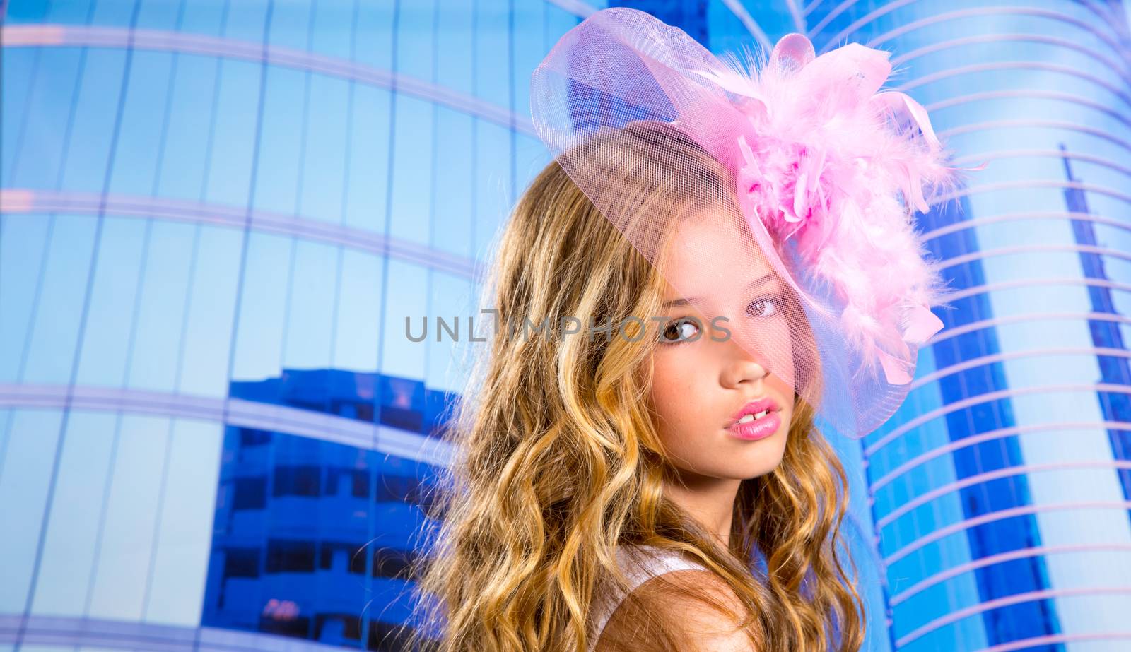 blond fashion girl with pink hat in blue skyscrapers buildings urban background