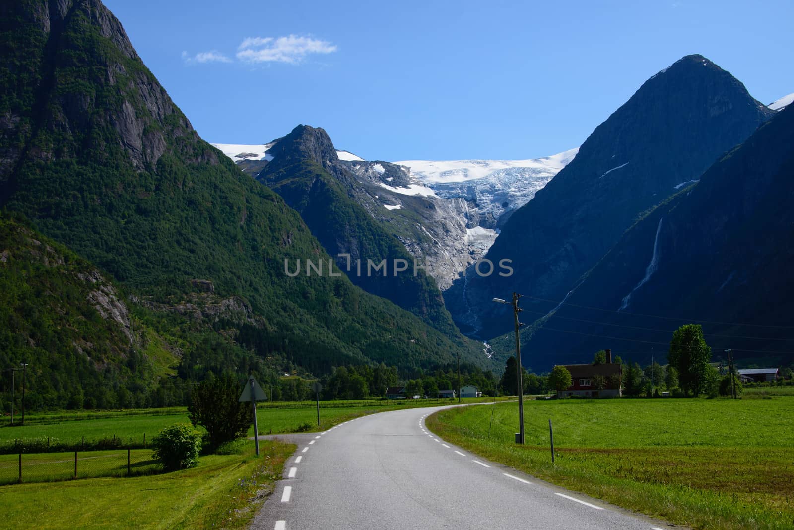 A country road in Norway with the glacier Briksdalsbreen far away