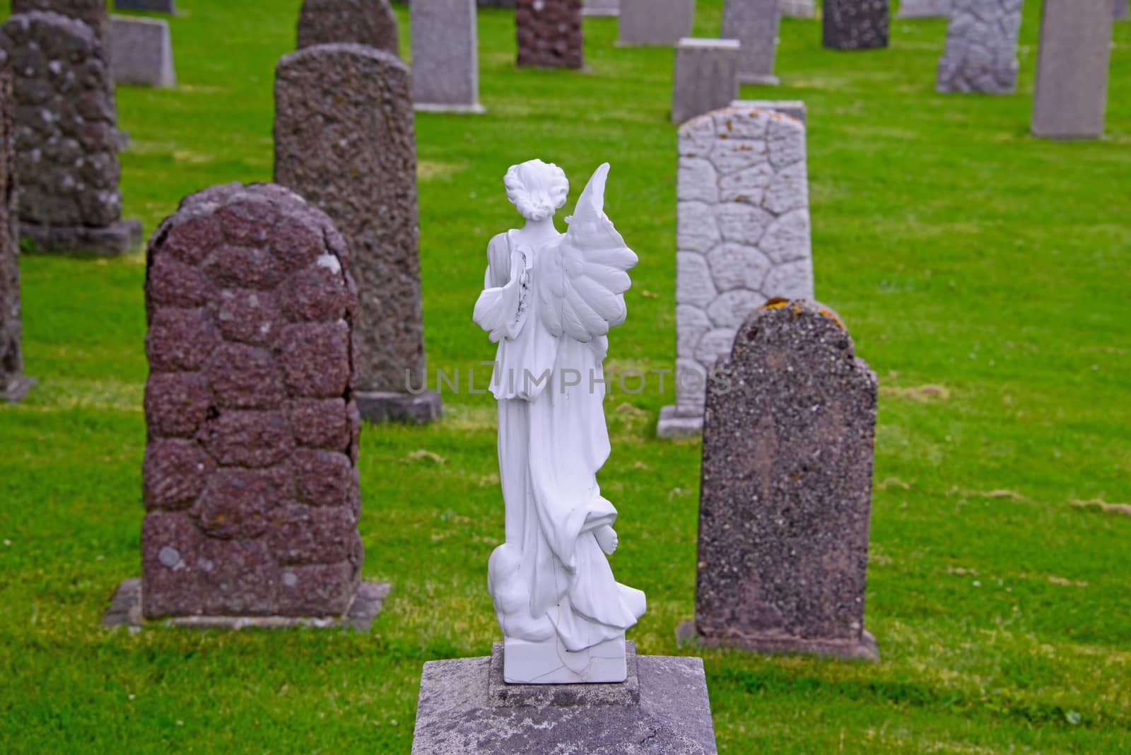 An marble angel watching over tombstones