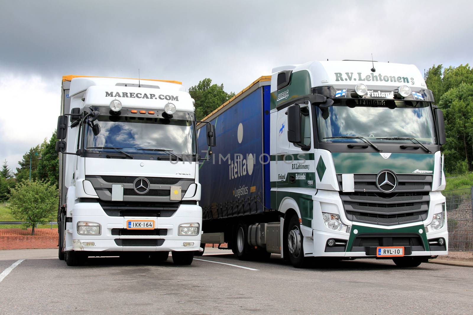 SALO, FINLAND - JUNE 15, 2013: Mercedes Benz Axor and Actros trucks on a parking lot in Salo, Finland on June 15, 2013. The Mercedes-Benz Actros 1851 GigaSpace wins Green Truck Award in 2013.