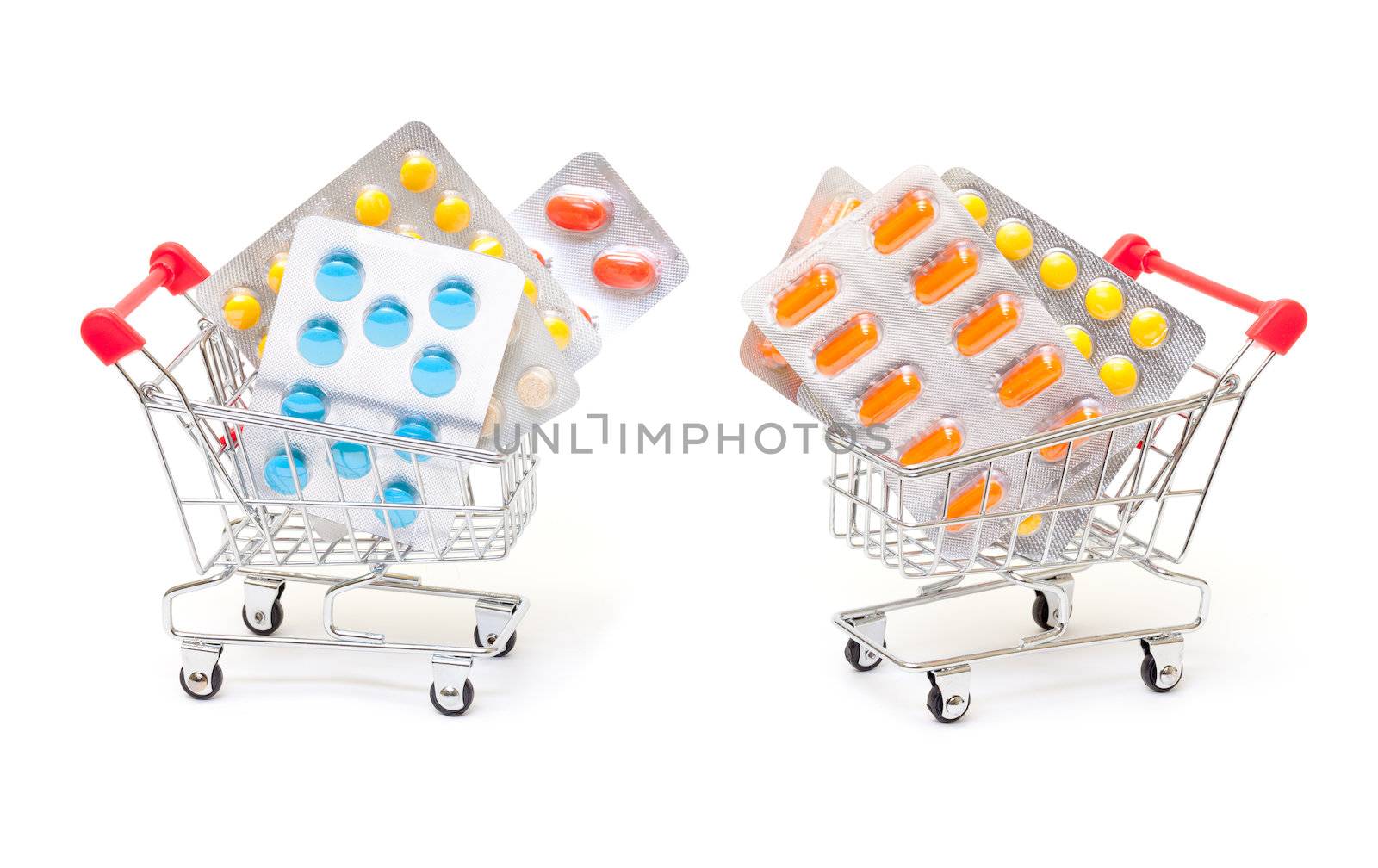 Multicolored pills packs in shopping cart, on white background