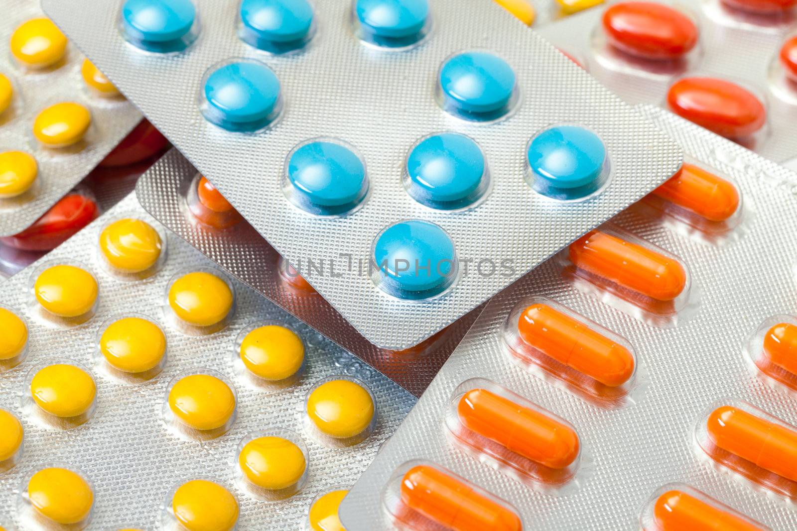 Multicolored pills packed in blisters, closeup