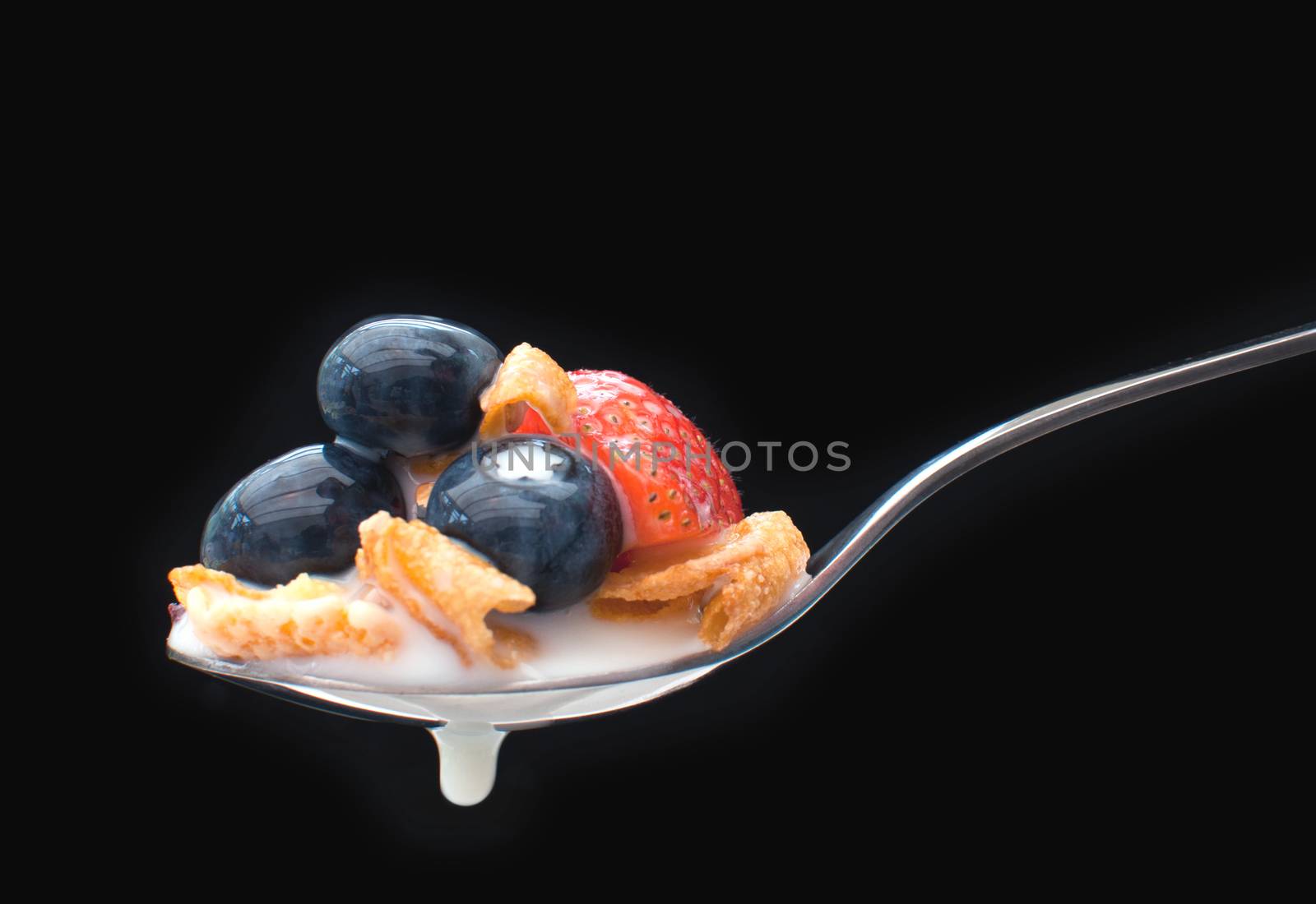 Breakfast cereal spoon with milk and berries  