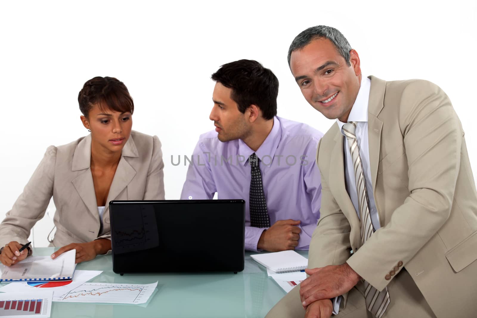 Three business colleagues at a desk by phovoir