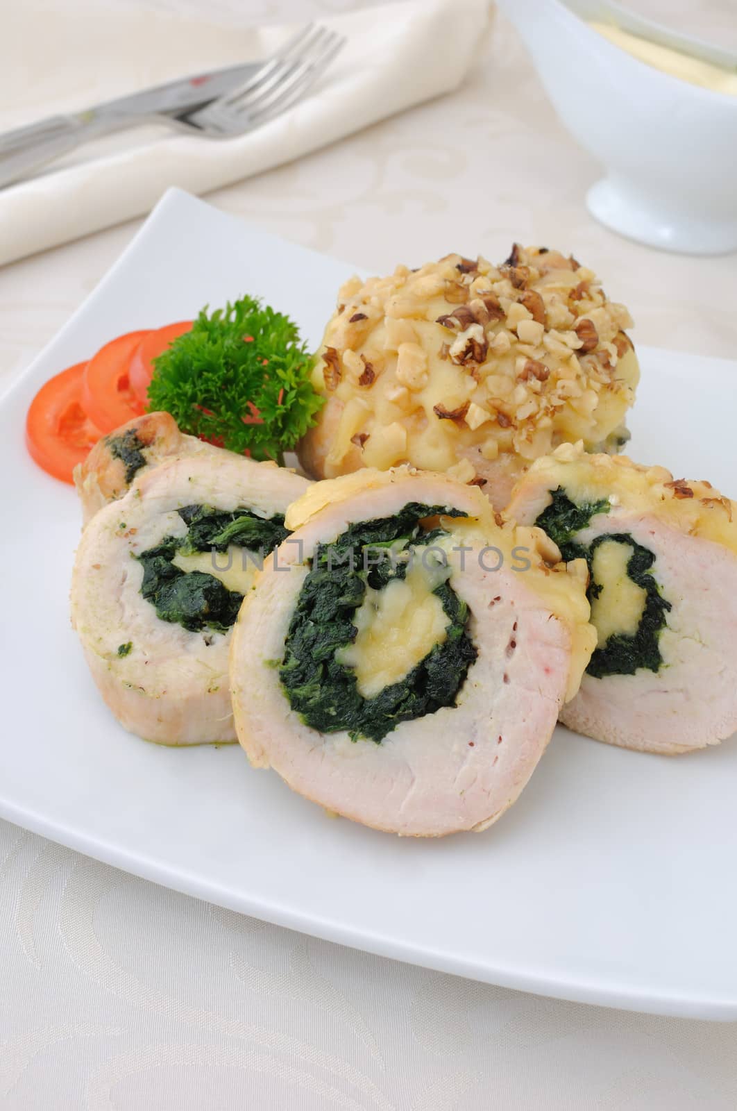 Sliced ​​chicken roll stuffed with spinach and mozzarella and cheese with walnuts