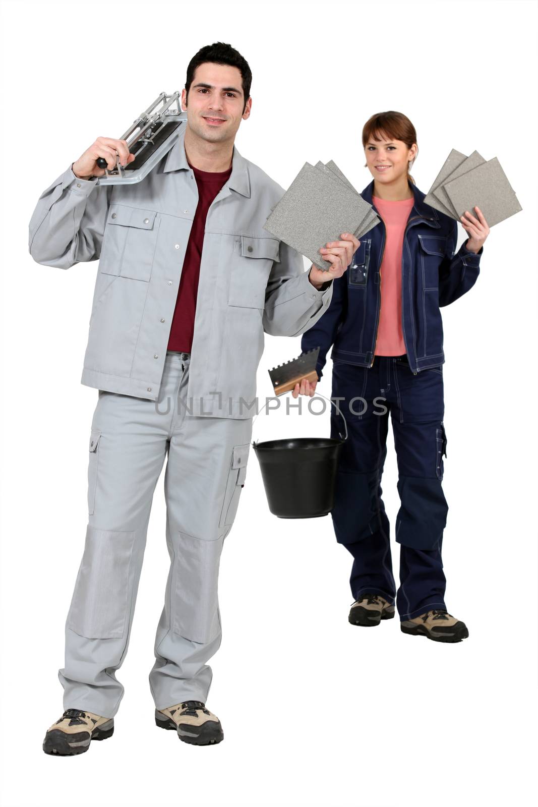 Tile fitters holding up their building supplies and tools by phovoir