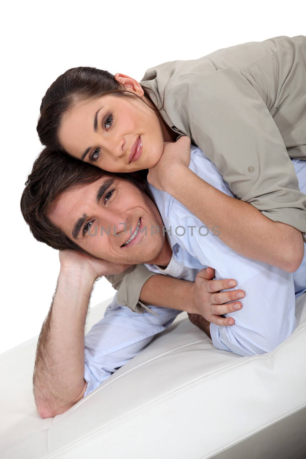 Portrait of a happy couple lying on a futon by phovoir