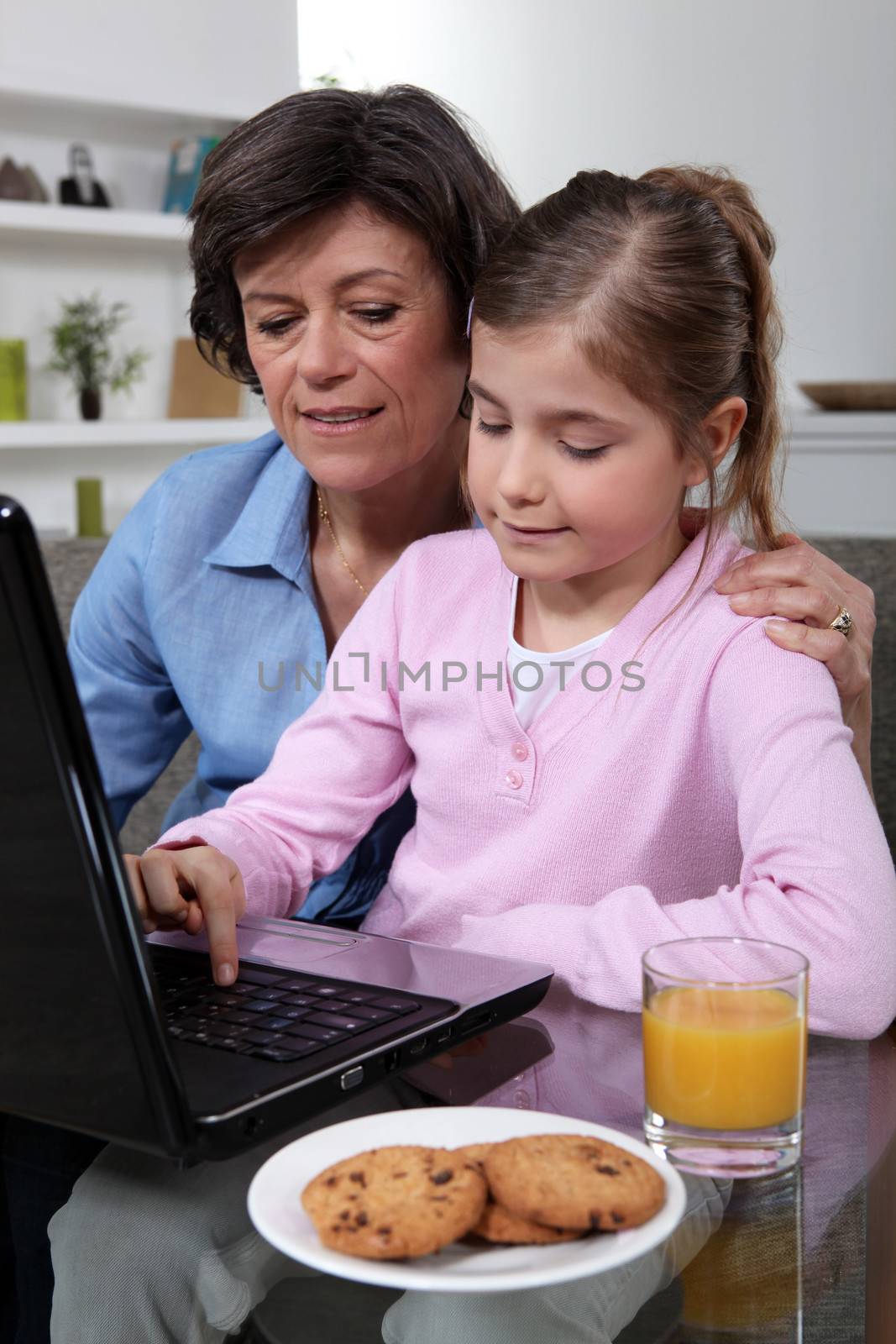 Mother and daughter sat at laptop