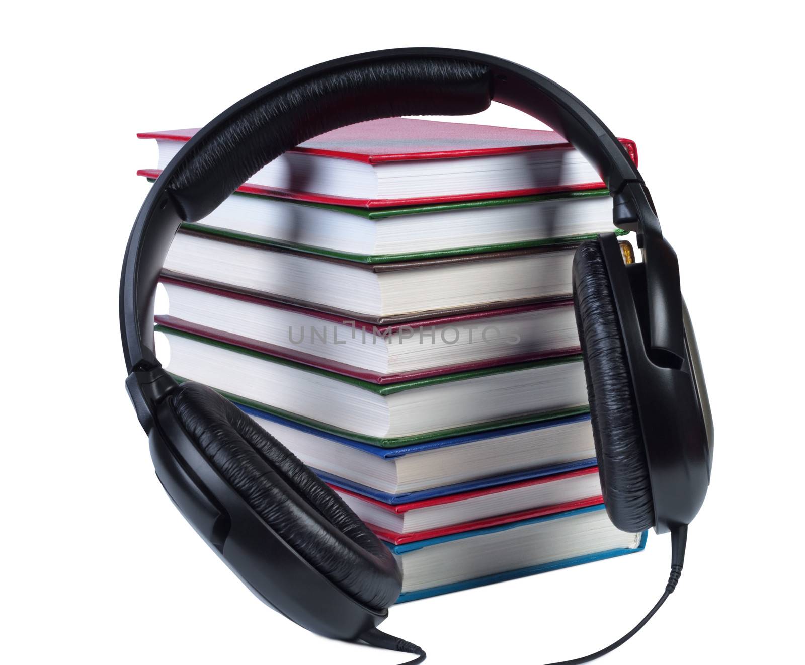 Audio headphones on a pile of books with color covers. Objects isolated white background.