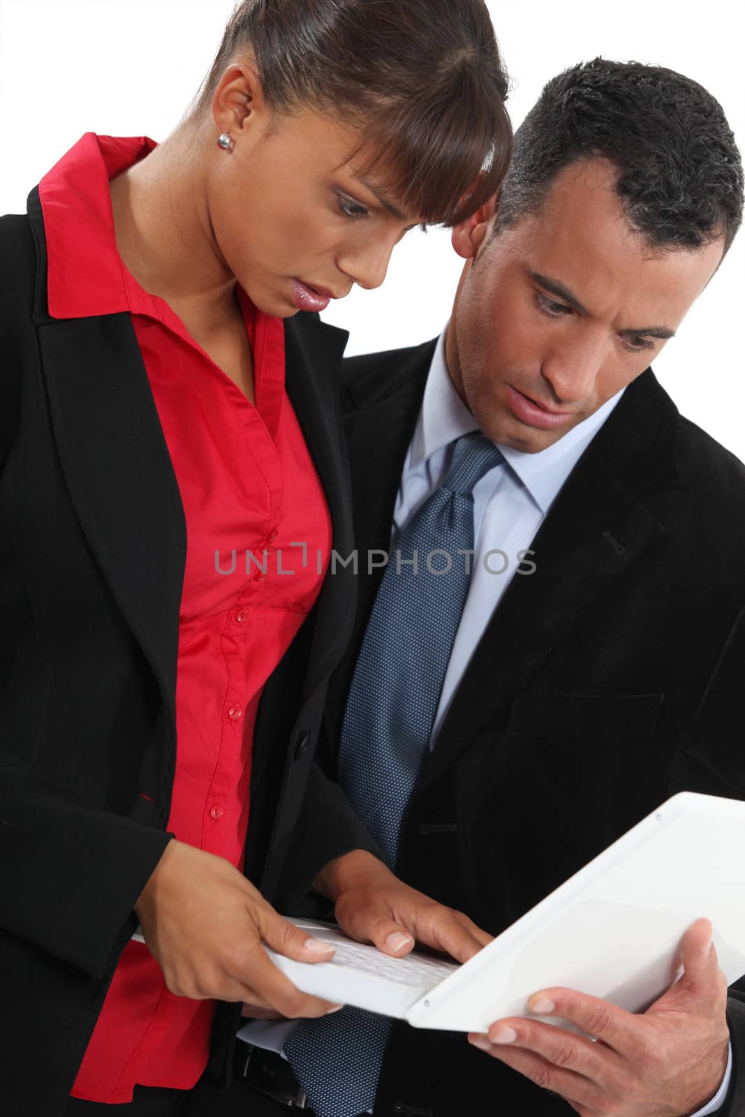 Businessman and businesswoman using laptop by phovoir