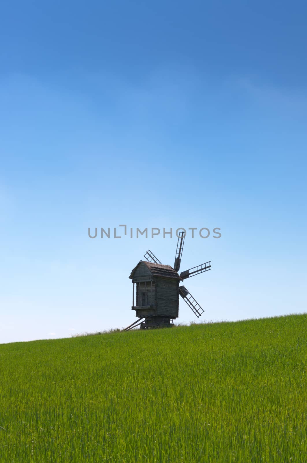Old wooden windmill in the field.