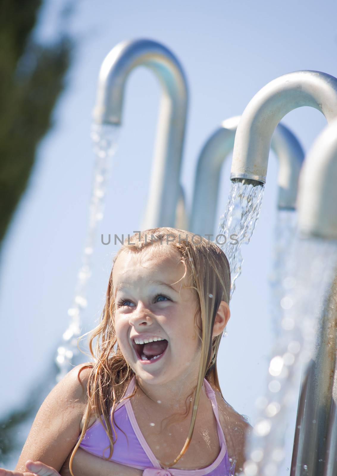 A little girl playing with water in a fountain