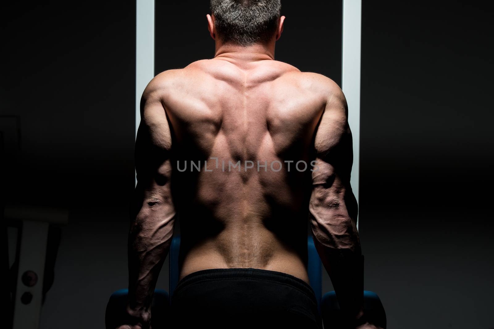 young male bodybuilder doing heavy weight exercise by JalePhoto