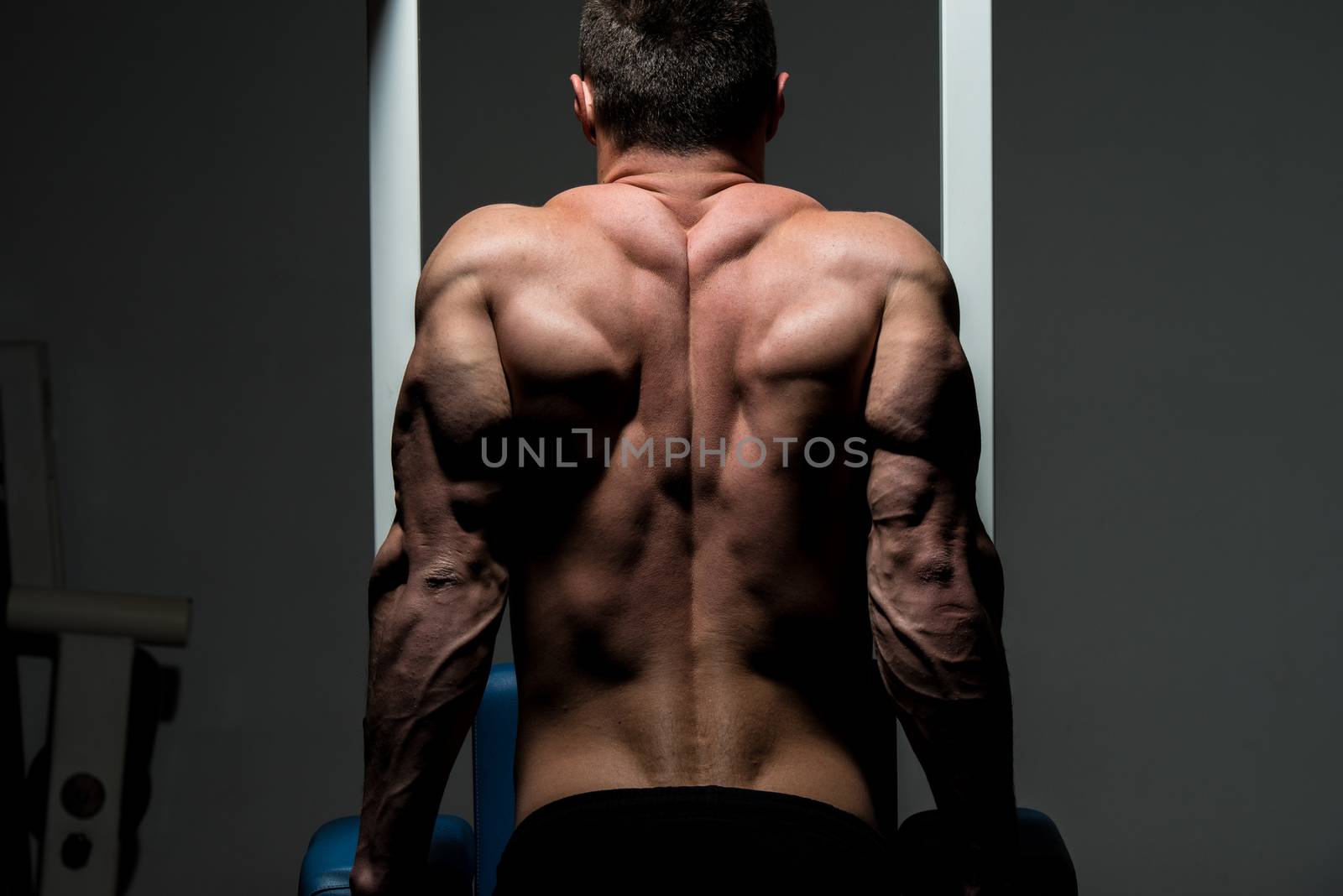 young male bodybuilder doing heavy weight exercise by JalePhoto