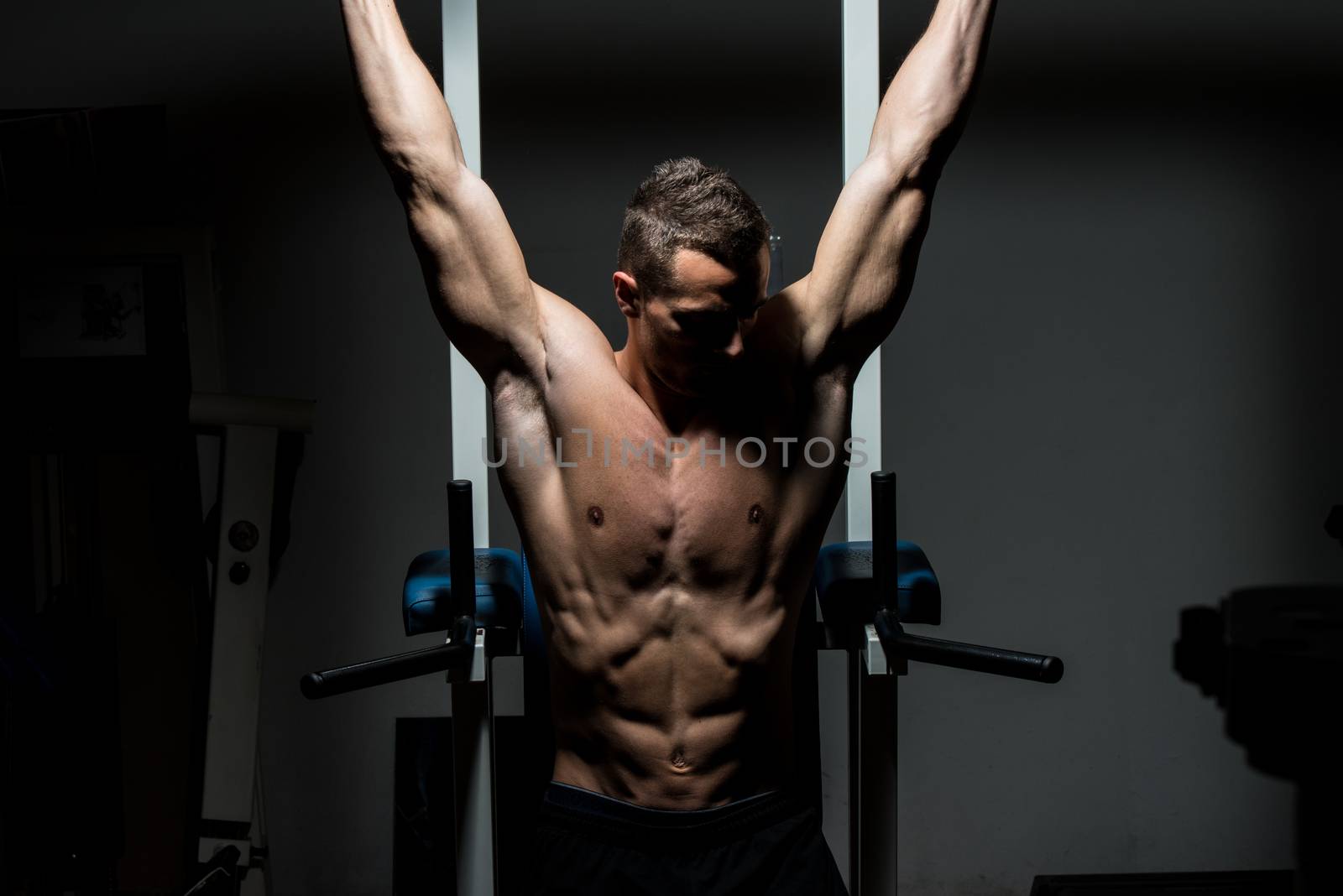 handsome man exercising his abs at the gym by JalePhoto