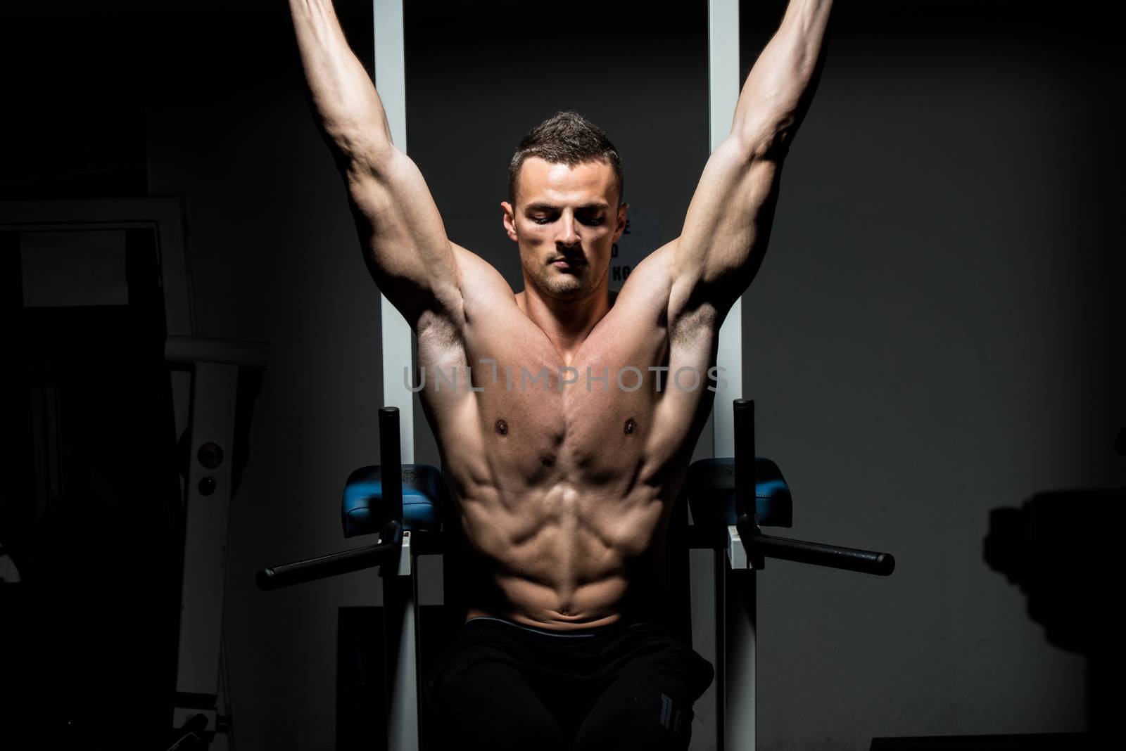 handsome man exercising his abs at the gym by JalePhoto