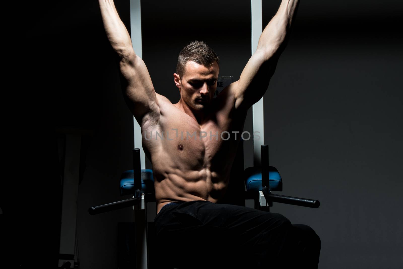 handsome man exercising his abs at the gym by JalePhoto