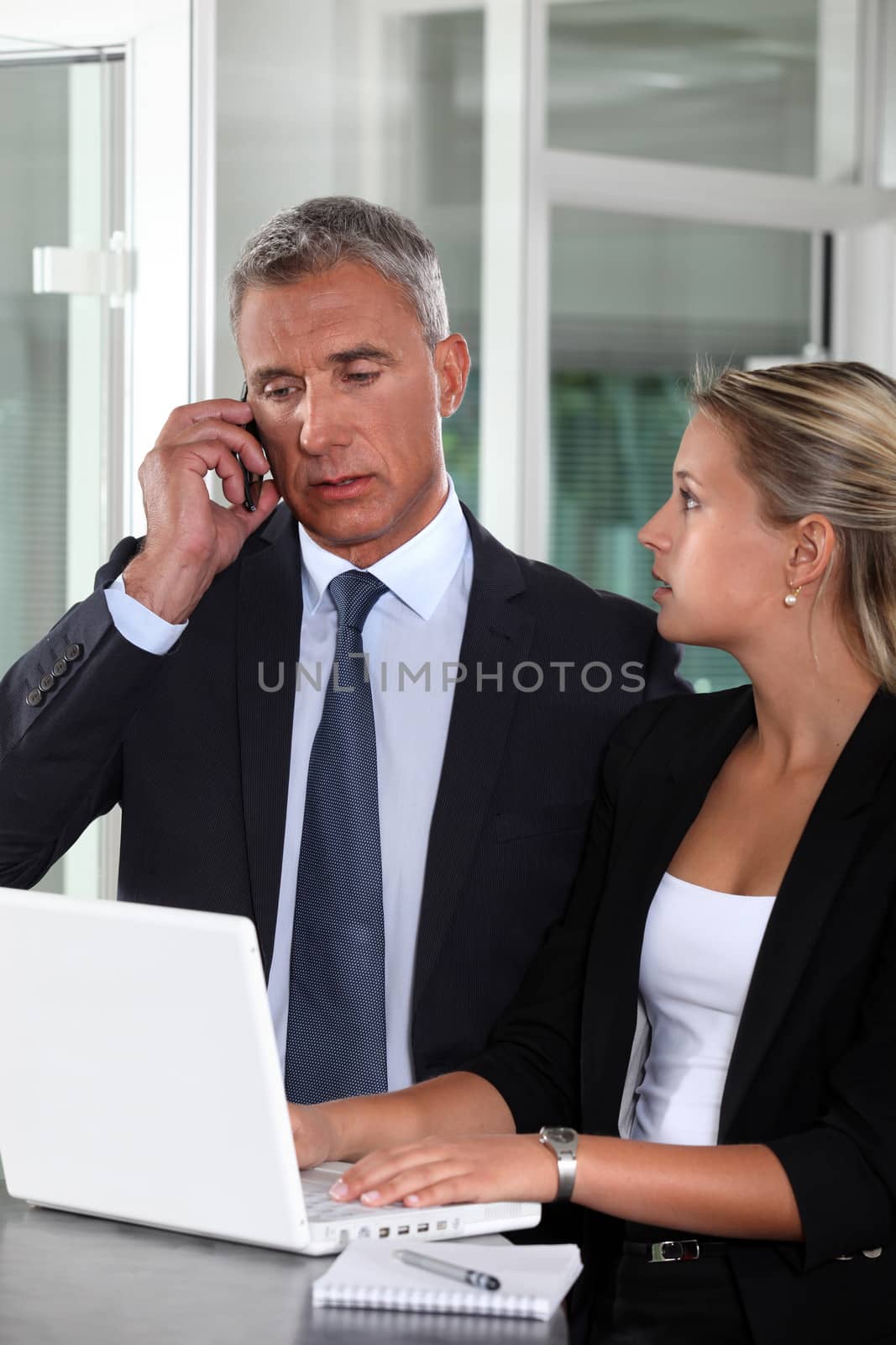 Boss working closely with female colleague by phovoir