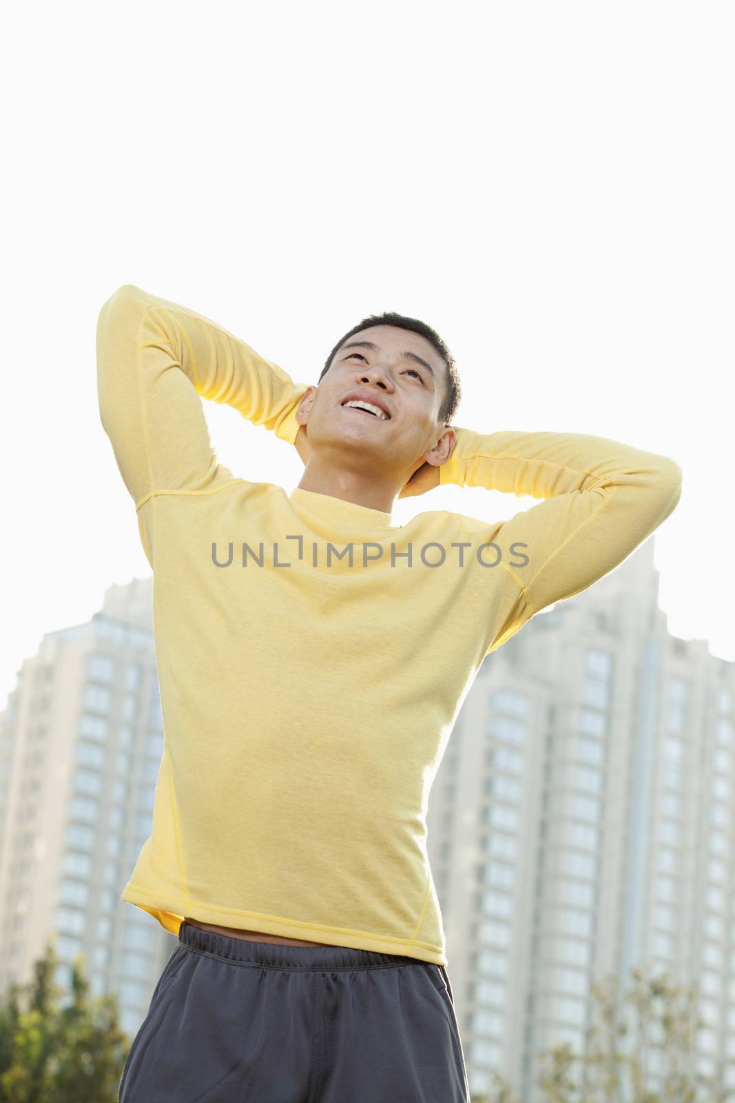 Young Athletic Man Standing in a Park in Beijing, Looking Up
