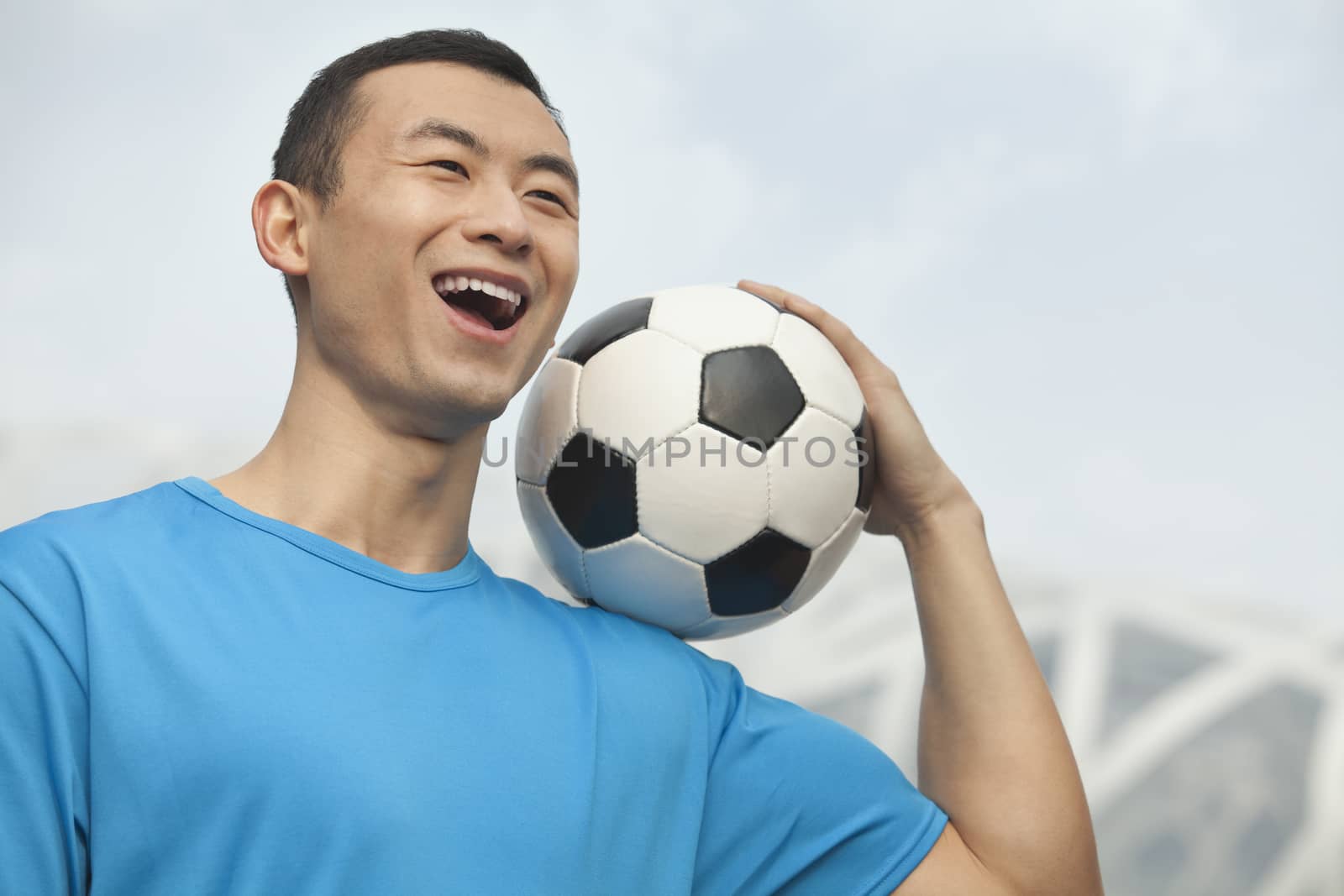 Young man holding soccer ball, Beijing