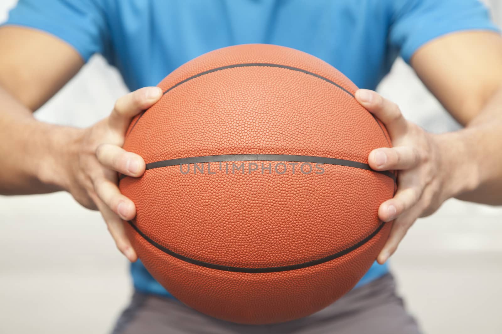 Close up of young man, midsection, holding a basketball