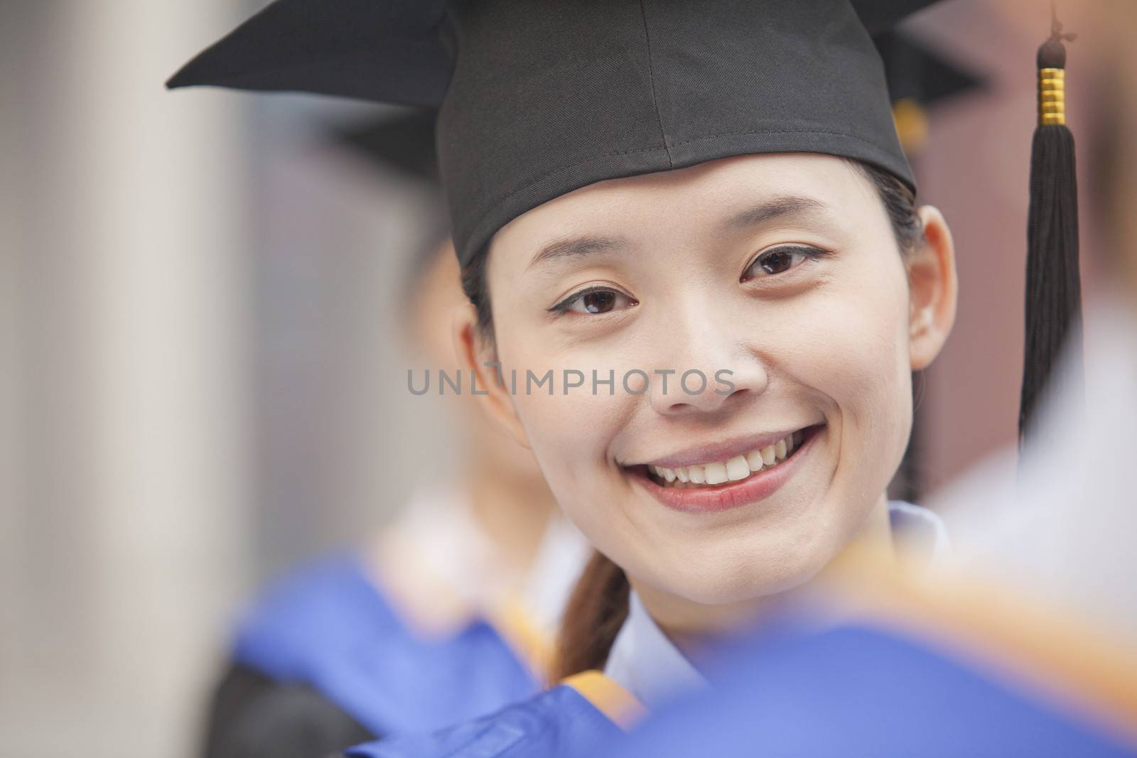 Close Up of Female Graduate Student Standing in a Row of Graduates