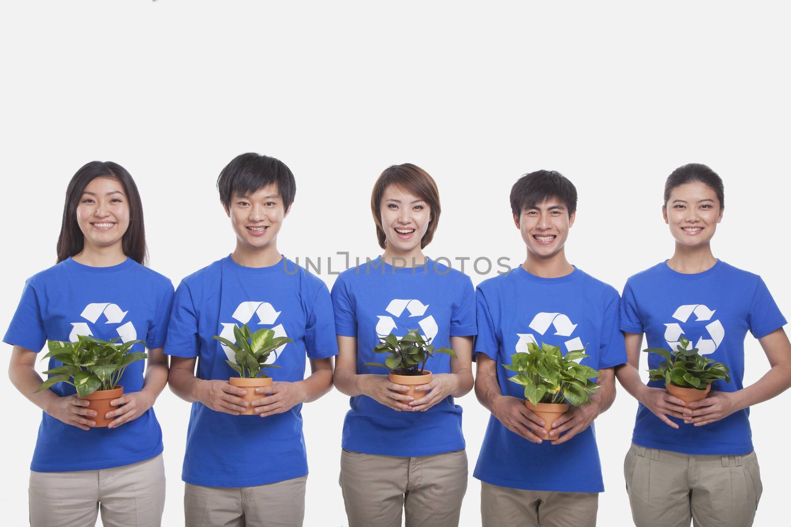 Group of people holding plants, studio shot