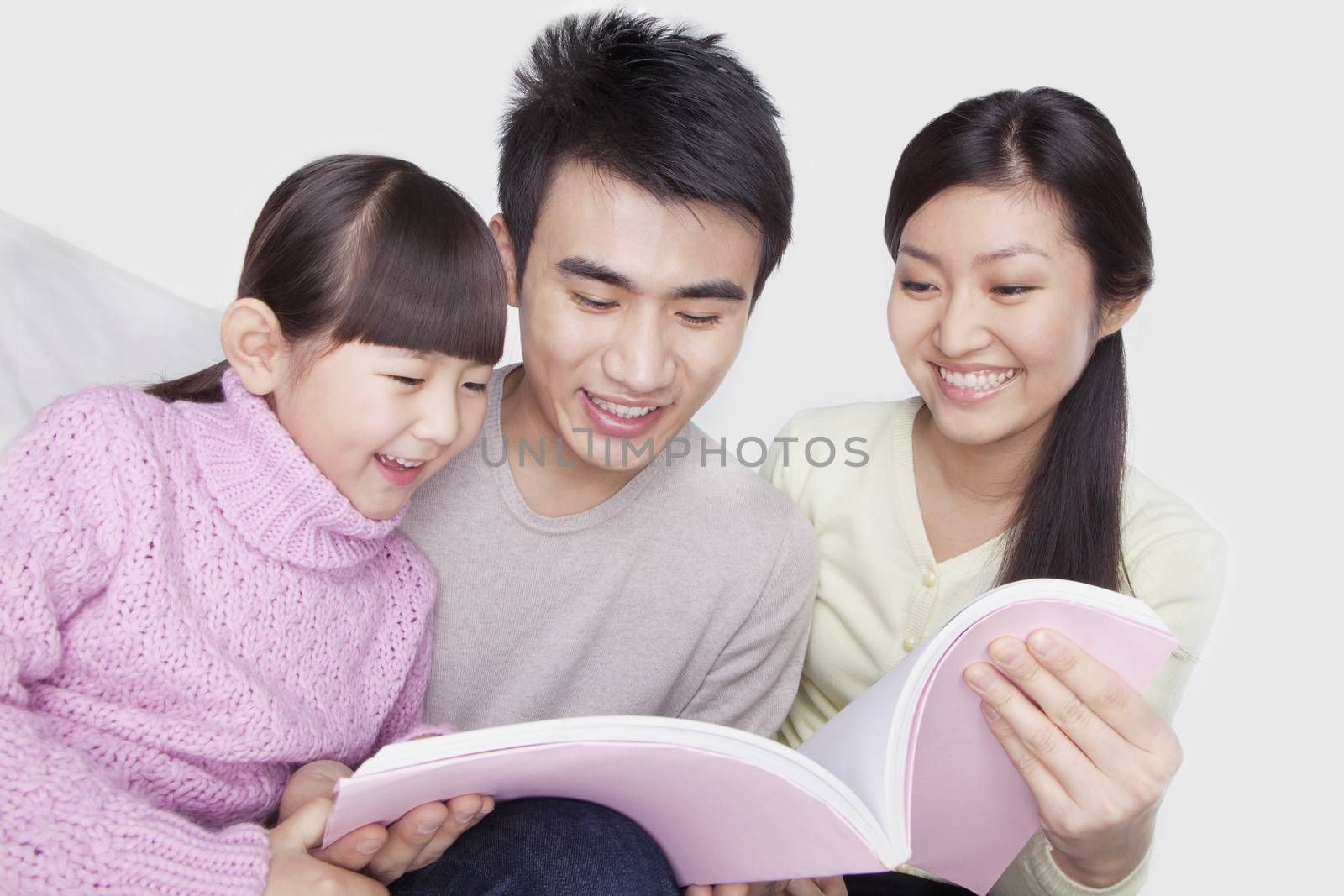 Family reading on the sofa, studio shot