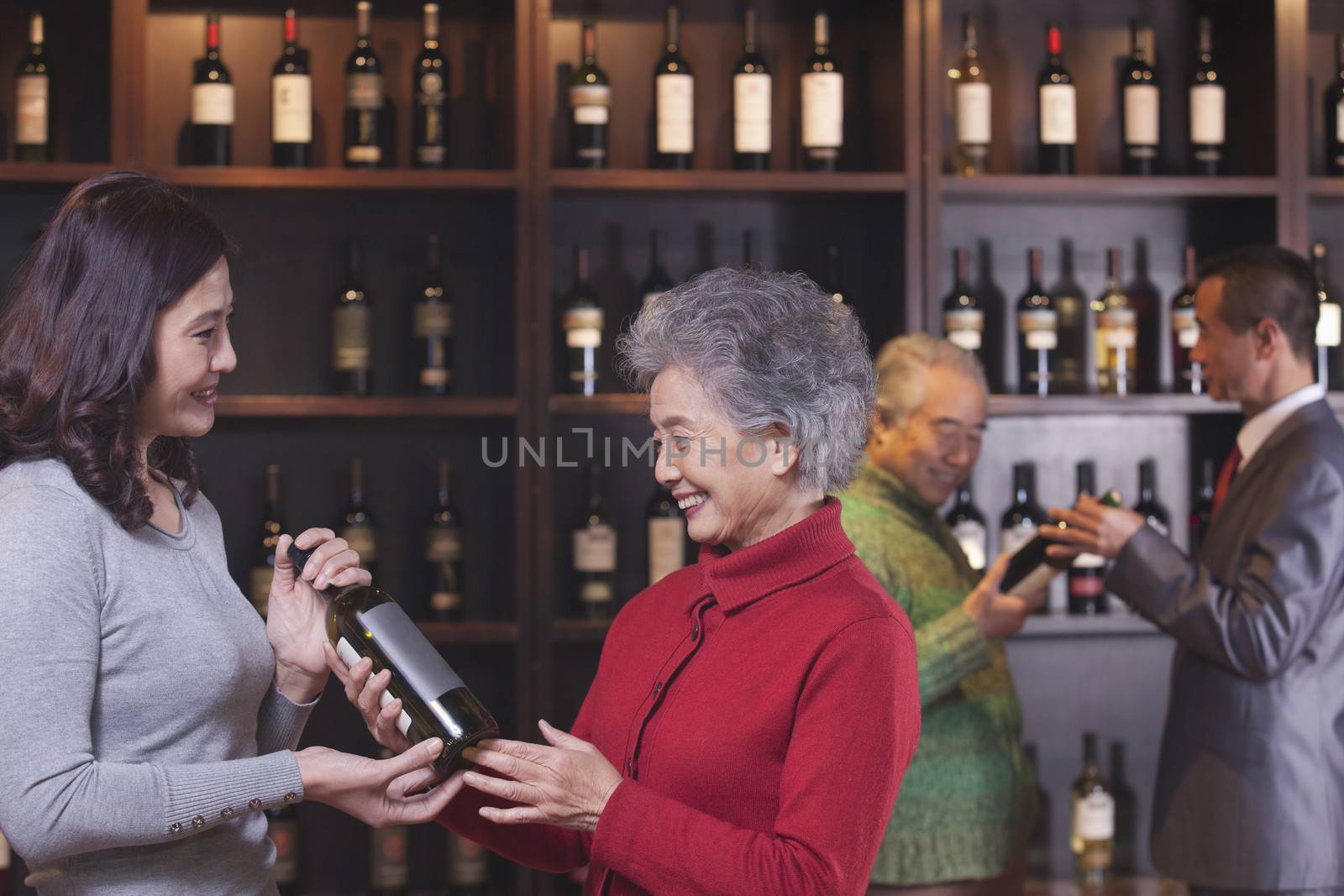 People Examining Wine Bottles, Two Women in the Foreground