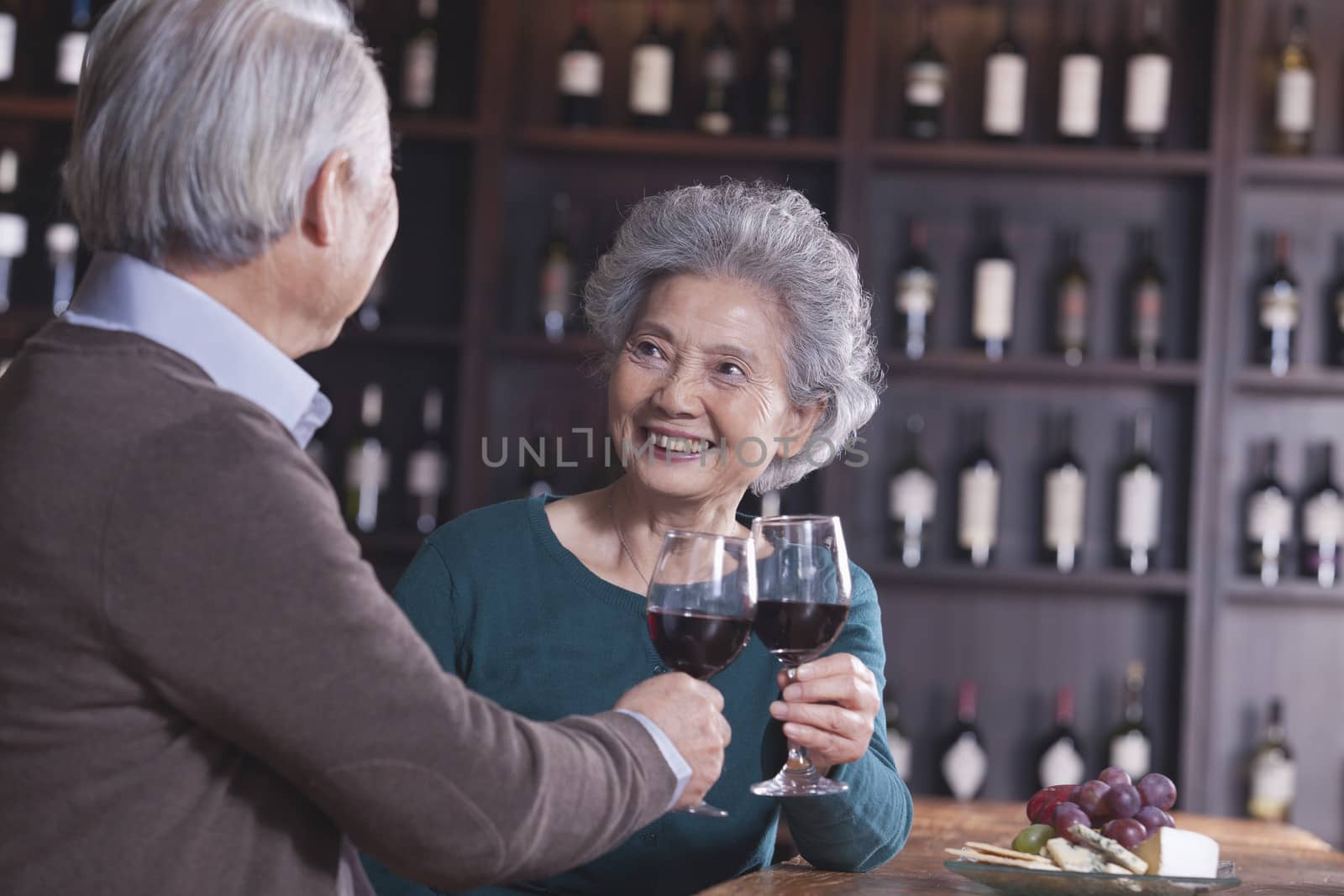 Senior Couple Toasting and Enjoying Themselves Drinking Wine, Focus on Female