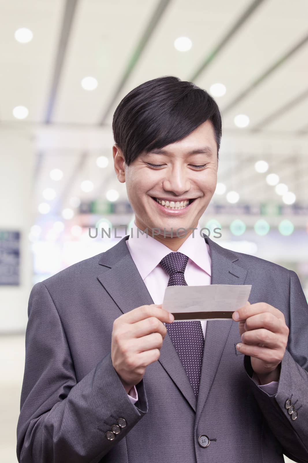 Young businessman looking at airplane ticket, Beijing