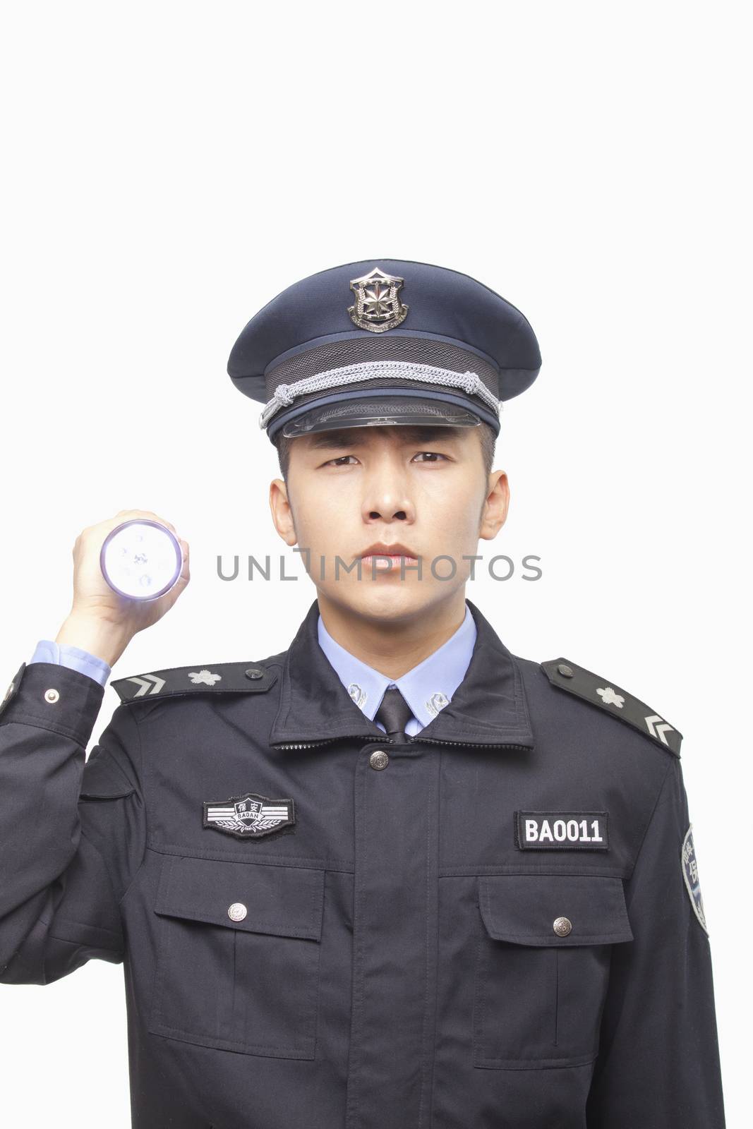Police Officer Shining Flashlight, Studio Shot