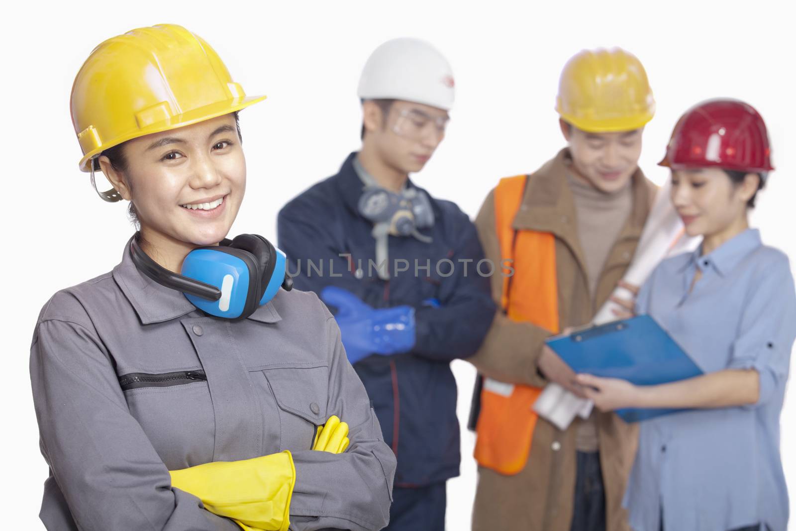 Four construction workers against white background, focus in foreground